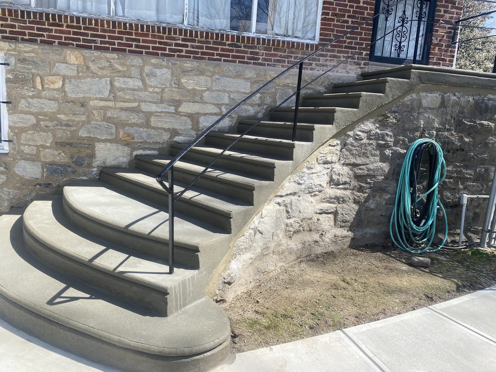 Concrete staircase along stone wall