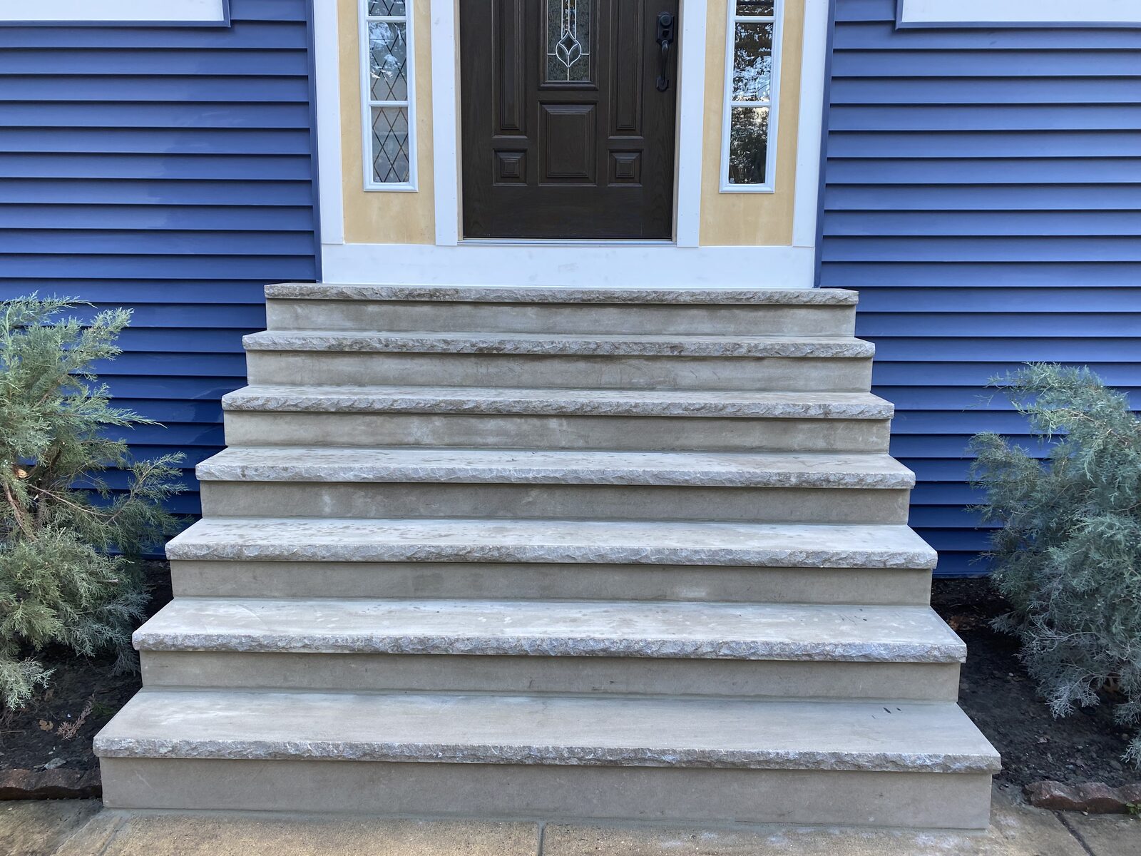Concrete front steps with rock-face edges